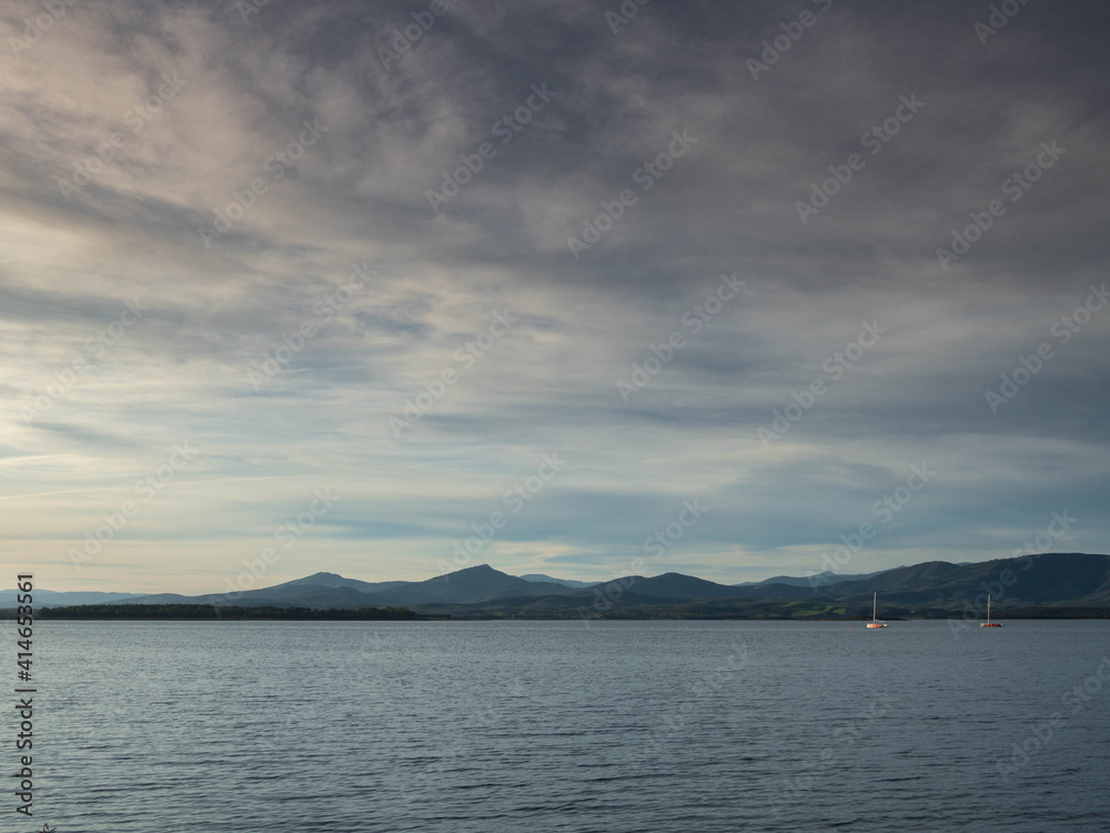 Lake with boats and mountains in the background