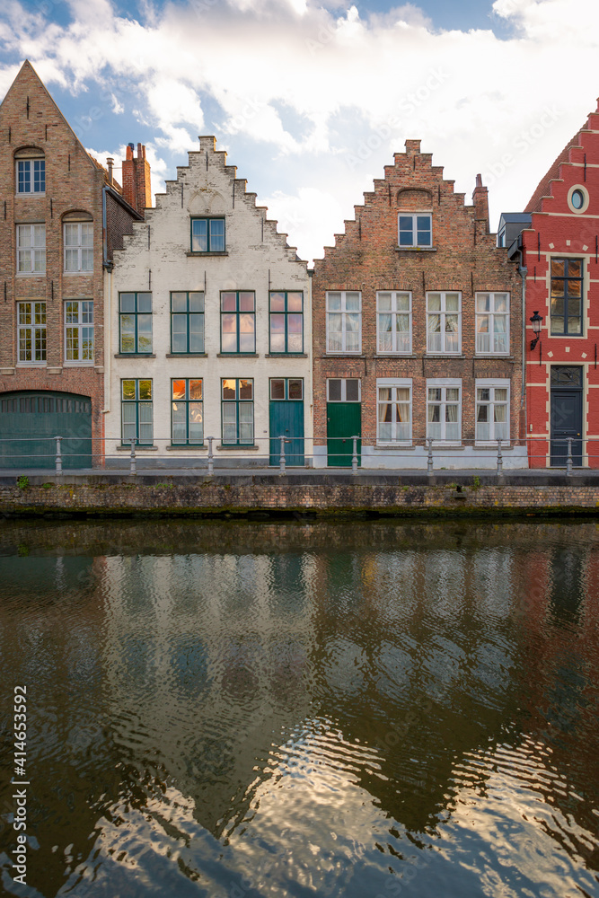 Twin facades but painted in different tones. Typical residential homes next to a channel in Brugge, Belgium.