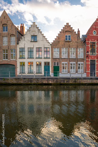Twin facades but painted in different tones. Typical residential homes next to a channel in Brugge, Belgium.