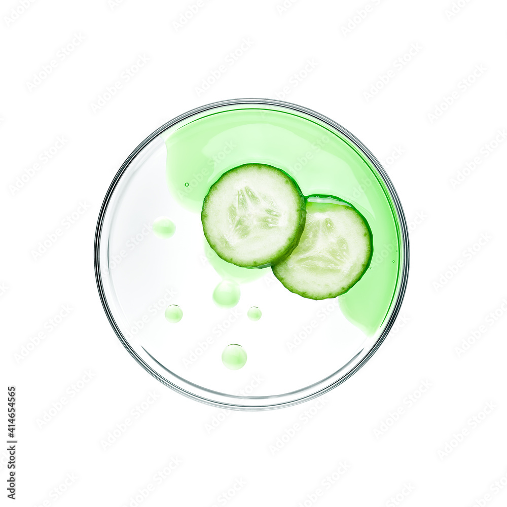Sliced cucumbers with essence on petri dish over white background