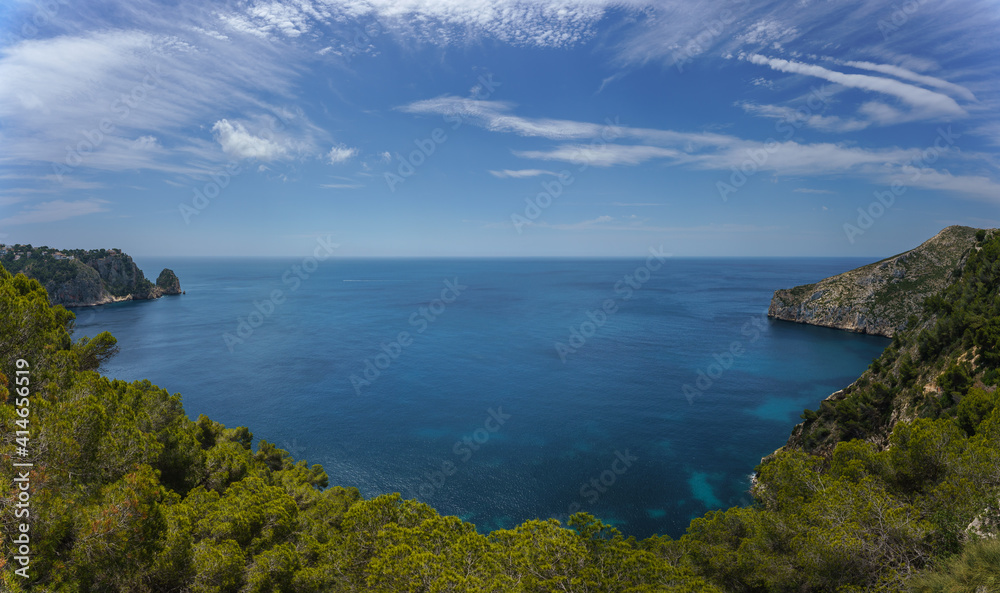 Panorama of the Spanish Mediterranean coast in the Region of Valencia with clean water, pine trees and some cliffs.
