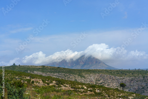 The Montgo, Denia Javea. Famous mountain covered with clouds. Landscape in Eastern Spain.  photo