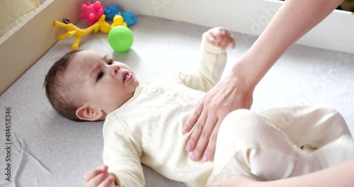 Mother massaging little baby .Baby skin care and development concept. Prevention of colic. Female hands doing tummy massage to newborn. slow motion