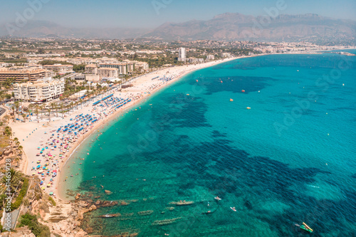 Spanish Mediterranean Sea Coast Landscape. Beach with turquoise water. Touristic sun and beach landmark in Playa del Albir, Comunidad Valenciana, Spain photo