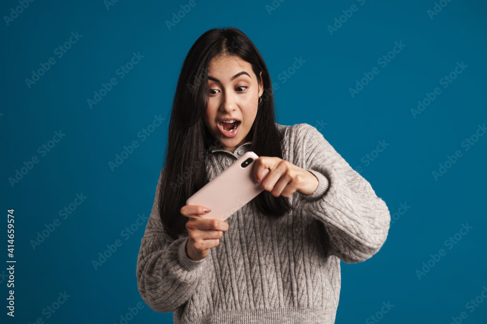 Excited beautiful asian girl playing online game on smartphone Excited beautiful asian girl playing online game on smartphone