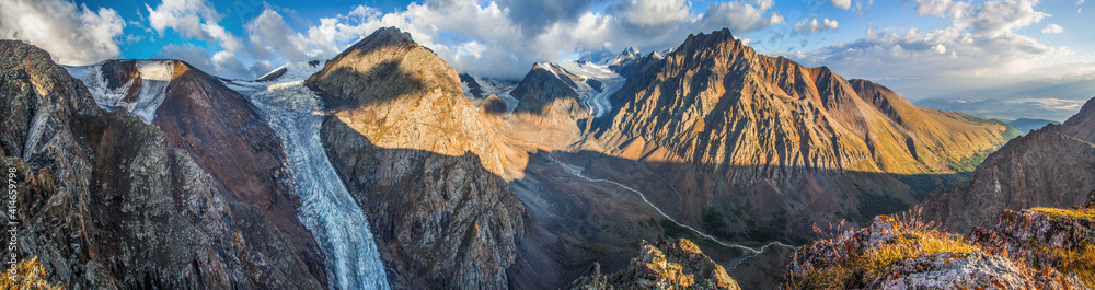 Panorama of mountains in morning light, rocky peaks and glaciers