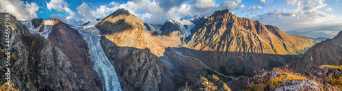 Panorama of mountains in morning light, rocky peaks and glaciers