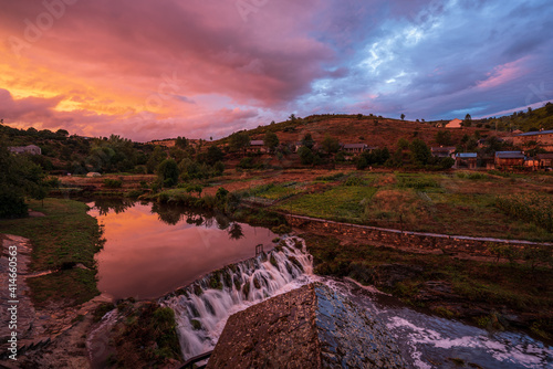 Colorful landscape in warm tones from yellow to red. A river flows through out the Portuguese-Spanish border at golden hour. Rio de Onor, Trás-os-Montes, Portugal photo