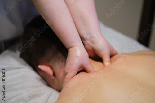 Close-up of man enjoying in relaxing neck massage . Man relaxing on massage table receiving massage