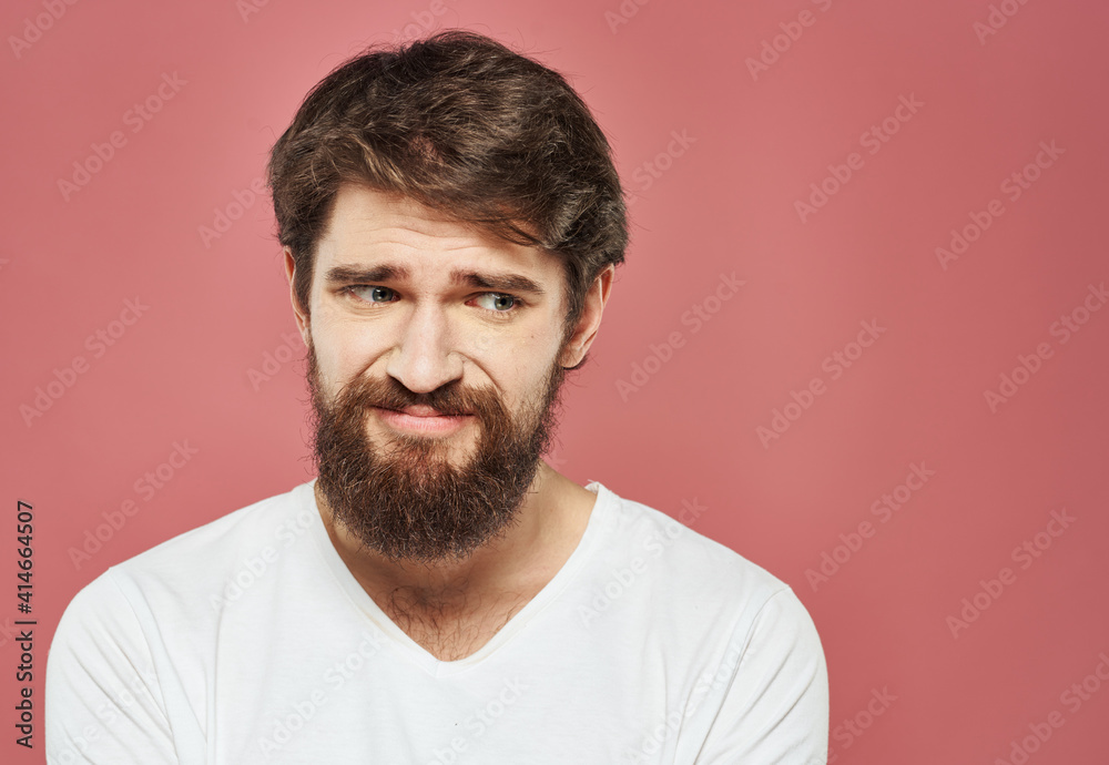 Man on a pink background portrait white t-shirt bushy beard