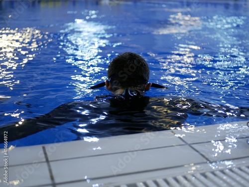 A diver in a neoprene wetsuit trains in the pool. A conrol of inexperienced divers photo