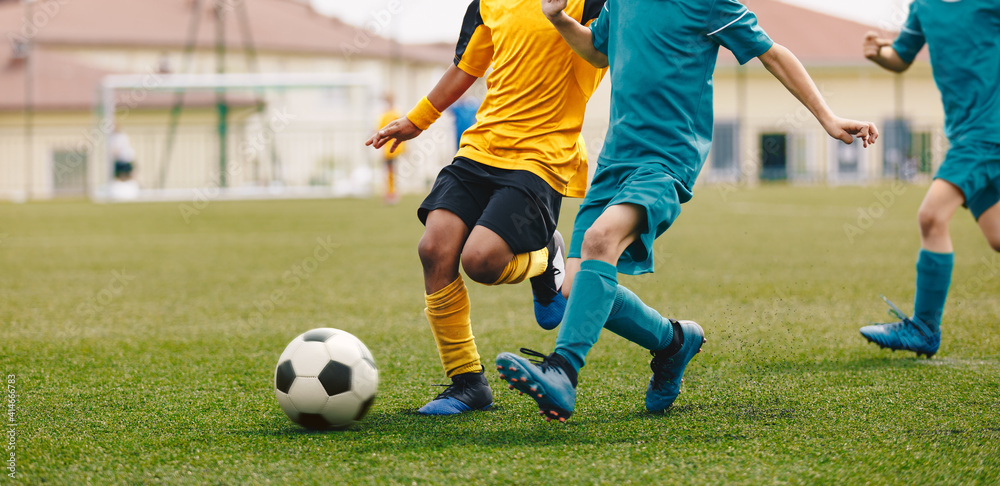 Obraz premium Running Footballers. Children Kicking Soccer School Tournament Match. Multiethnic Children Playing Sports. Young Athletes Compete in Football Game