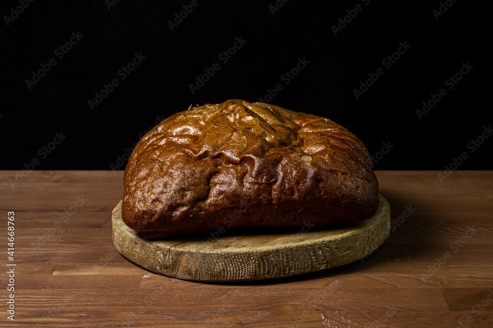 Black bread on a black background. Borodino bread. Homemade baking. Bakery product. Peasant food