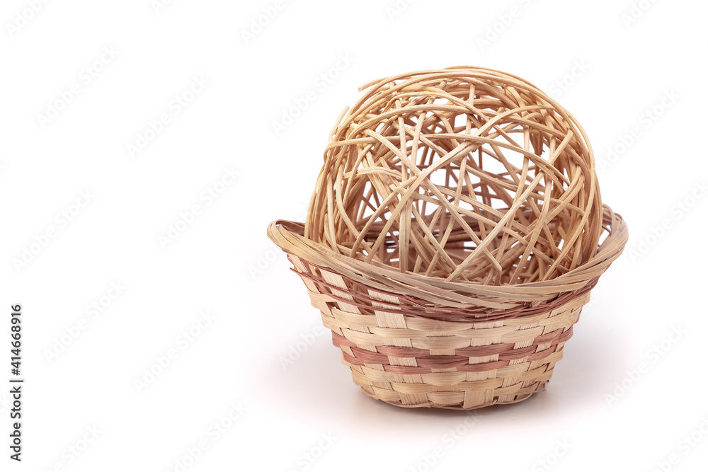 Wicker rattan ball in a wicker basket on a white background