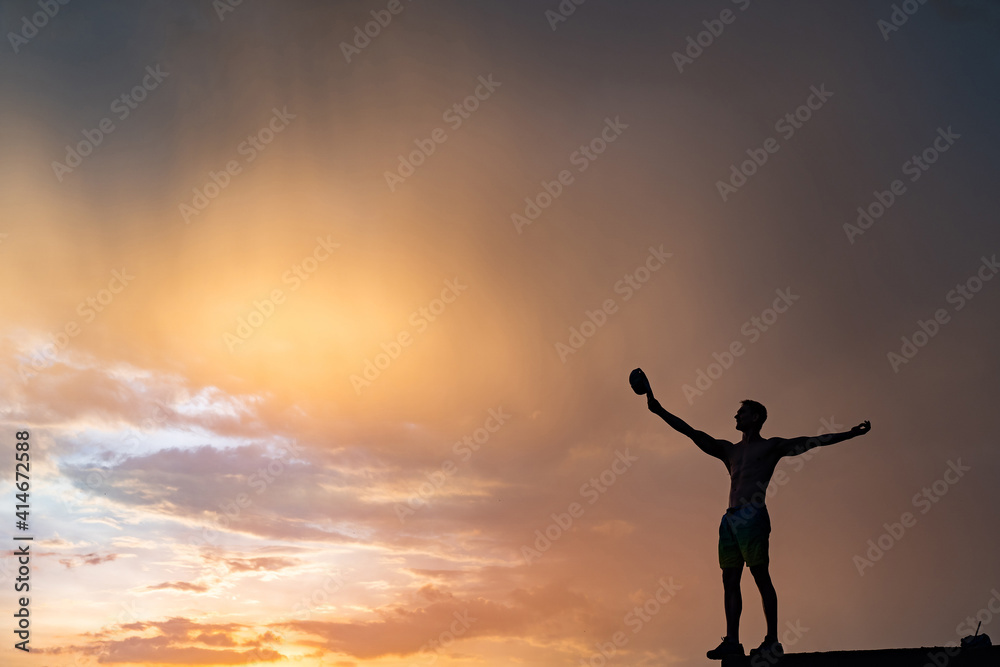 Silhouette of Man stepping from the edge during dramatic sunset. Concept goal, step forward and risk Silhouette of Man stepping from the edge during dramatic sunset. Concept goal, step forward and risk