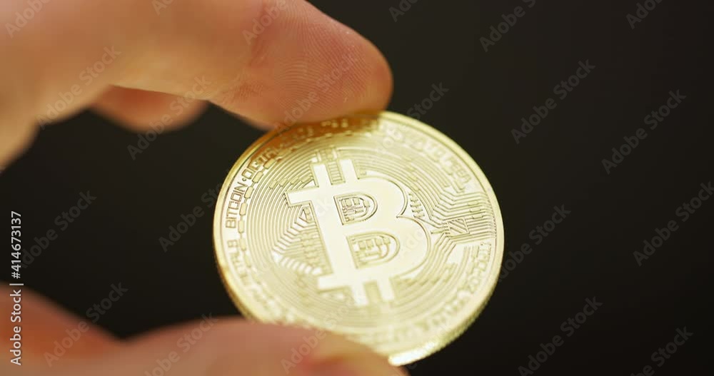 Inspecting Physical bitcoin held in hands closeup Inspecting Physical bitcoin held in hands closeup