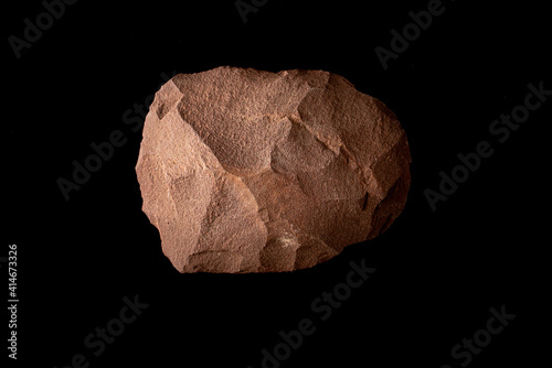 Beautiful paleolithic quartzite splitter very well preserved on a black background photo