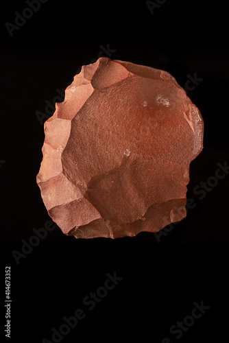 Beautiful paleolithic quartzite splitter very well preserved on a black background. vertical photography photo