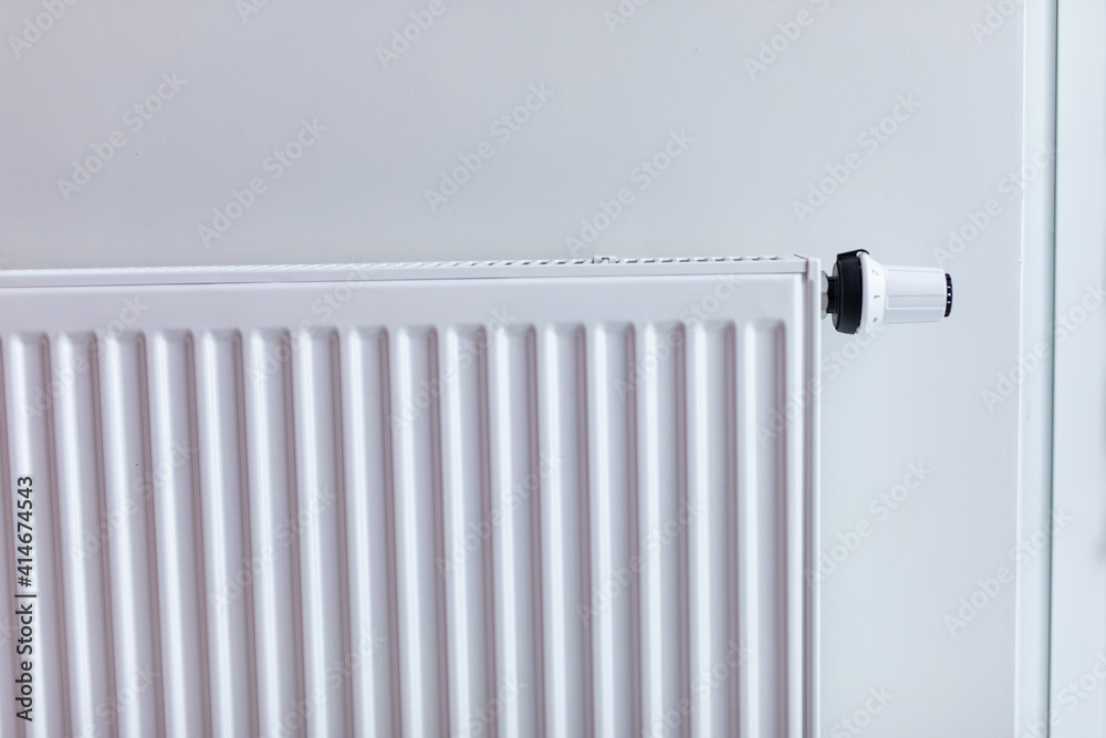 White radiator with temperature control valve. Central heating battery. White radiator with temperature control valve. Central heating battery.