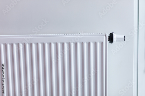 White radiator with temperature control valve. Central heating battery.