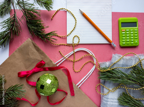 Obraz na płótnie Photo of New Year's flat lei.
Photo top view of coniferous branches, gift bag. Pink background. w salonie