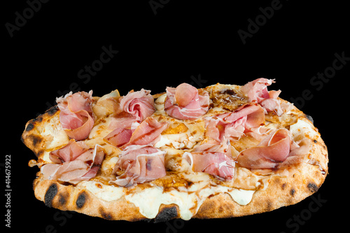 Scrocchiarella with pear, cheese, prosciutto on black background. Pinsa romana gourmet italian cuisine. Food delivery from pizzeria. Junk food photo