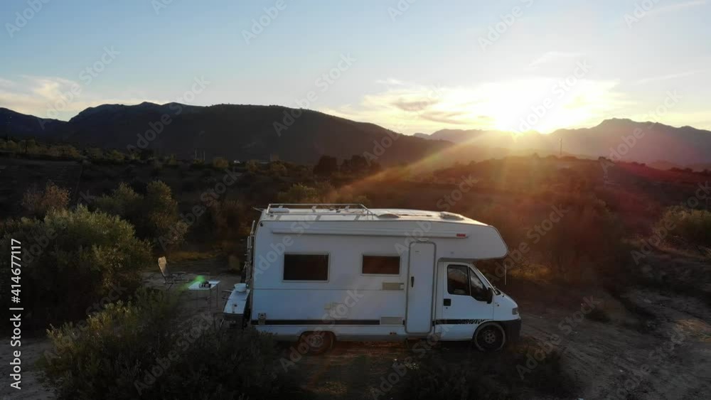 Aerial view. Motorhome camper car on roadside in spanish hills mountain nature at sunset. Travelling in caravan. Aerial view. Motorhome camper car on roadside in spanish hills mountain nature at sunset. Travelling in caravan.