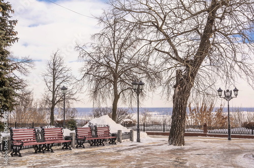 Winter cityscape with benches and lanterns on the boulevard photo