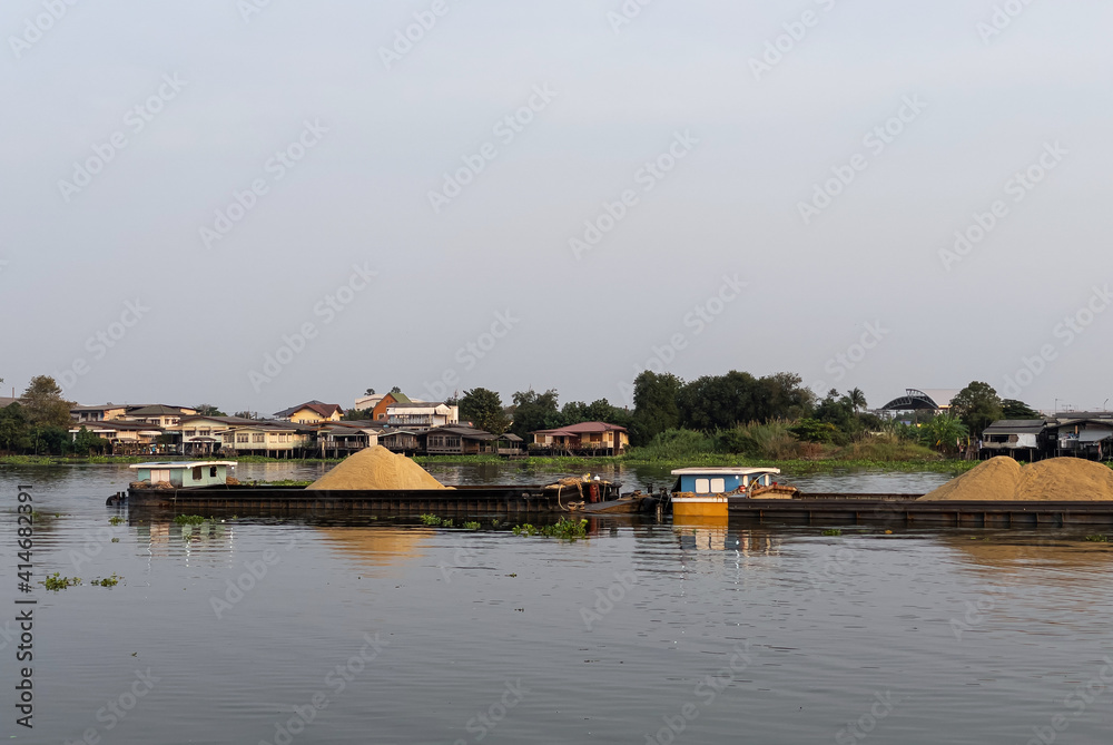 The large cargo boat is loading the much sand for transport to the construction site. The large cargo boat is loading the much sand for transport to the construction site.