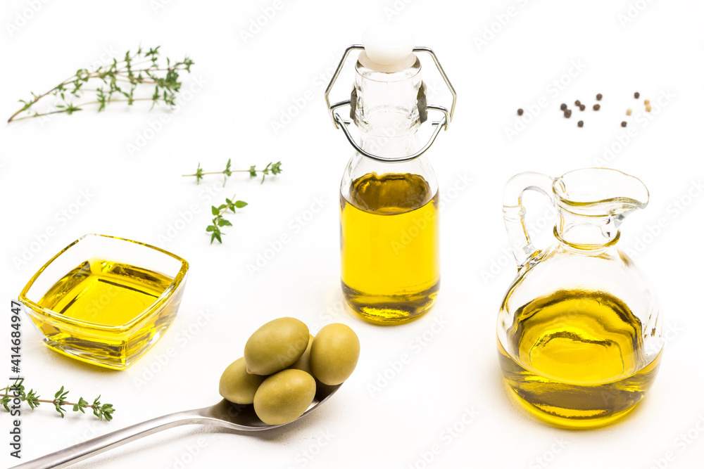 Green olives in metal spoon. Olive oil in glass jar. Thyme sprigs Green olives in metal spoon. Olive oil in glass jar. Thyme sprigs