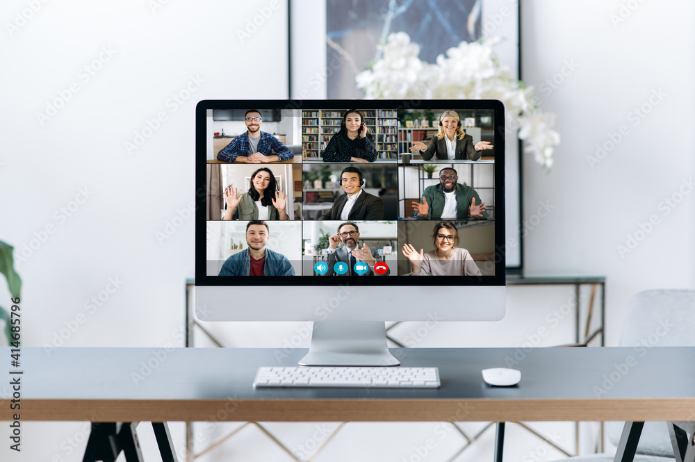 Virtual meeting, online briefing, brainstorm. A computer stands on the desktop, on the computer screen is many different multiracial business partners, gathered and communication in a video call Virtual meeting, online briefing, brainstorm. A computer stands on the desktop, on the computer screen is many different multiracial business partners, gathered and communication in a video call