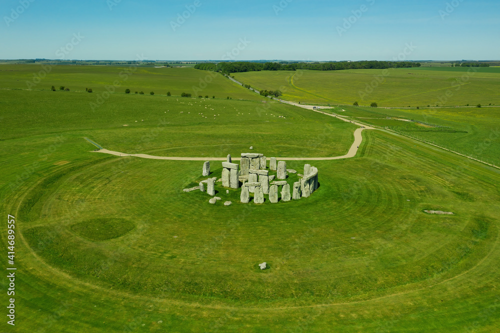 Aerial view of Stonehenge on a sunny day in summer with no people around. This is a historic site with a ring of standing stones, it was believed to be a burial site. Blue sky with space for text. Aerial view of Stonehenge on a sunny day in summer with no people around. This is a historic site with a ring of standing stones, it was believed to be a burial site. Blue sky with space for text.