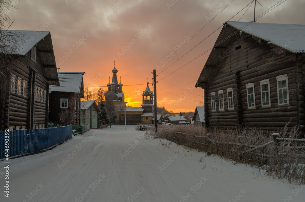 Dawn in the northern village of Kimzha. Temple in the name of the Odigitrievskaya Icon of the Mother of God, village houses and fences. Russia, Arkhangelsk region, Mezensky district 