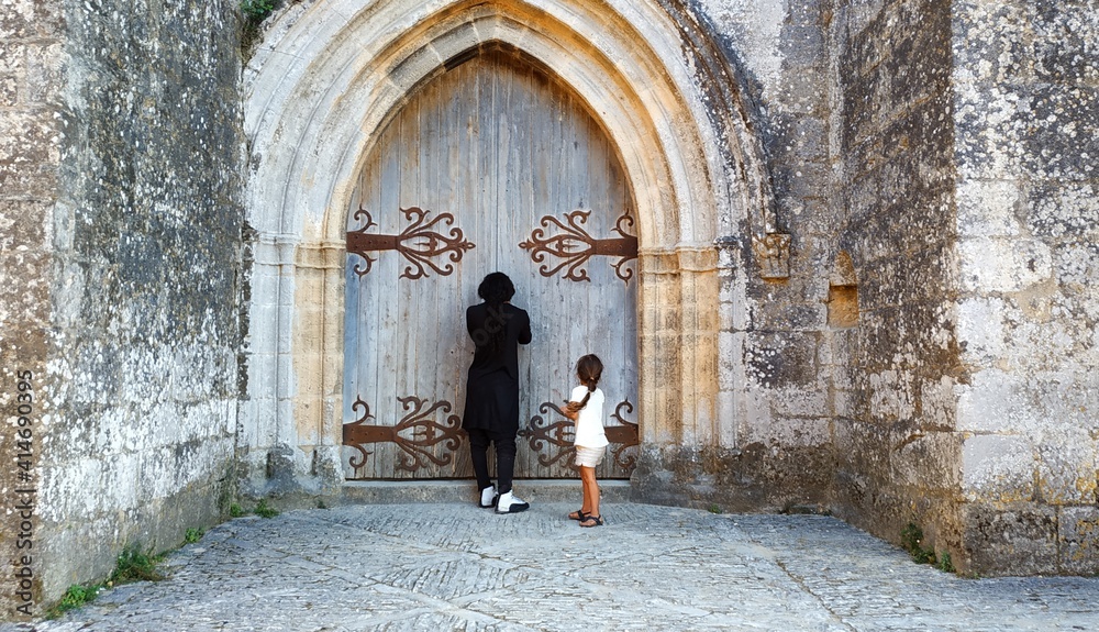 Un padre y su hijo tratan de ver por el ojo de la cerradura de un castillo medieval francés
