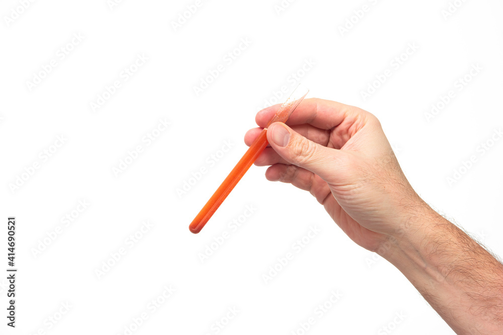 Test tube vial with red liquid held by Caucasian male hand isolated on white background studio shot Test tube vial with red liquid held by Caucasian male hand isolated on white background studio shot