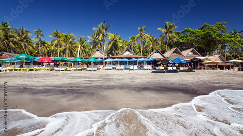 White sand beach Bali with sand and palm trees and waves photo