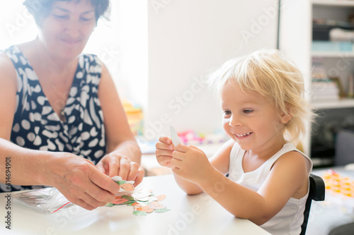Grandmother  teaching her grandson alphabet and numbers  educating