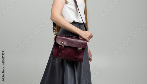 Photography Small red leather bag over a woman shoulder on a white background