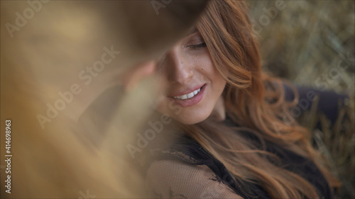 the girl is lying with the guy in his arms. they are sitting on a blanket. drink a hot drink. open air. love