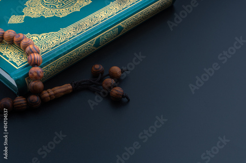 Holy Quran with arabic calligraphies translation meaning of Al-Quran and Rosary or Tasbih on black background. Ramadan,Hajj, Islamic and Copy Space concept