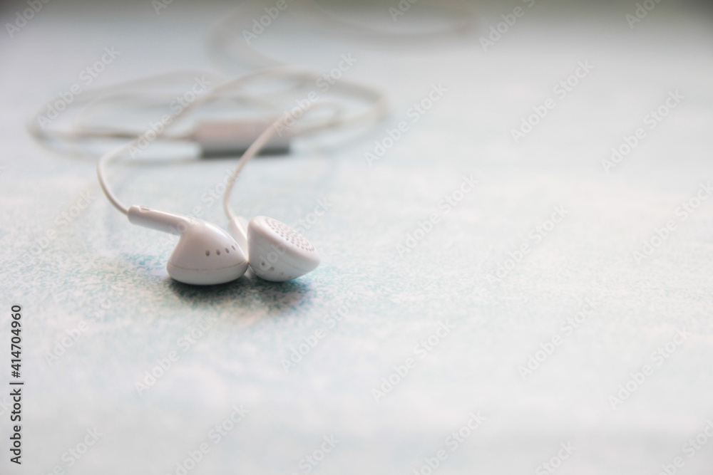 Fototapeta premium White Headphones On A blue Background, Earphone, accessory.