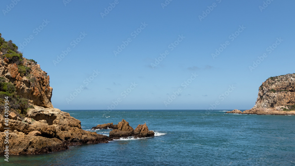 View of a river flowing out to sea between two cliffs at the Heads, Knysna
