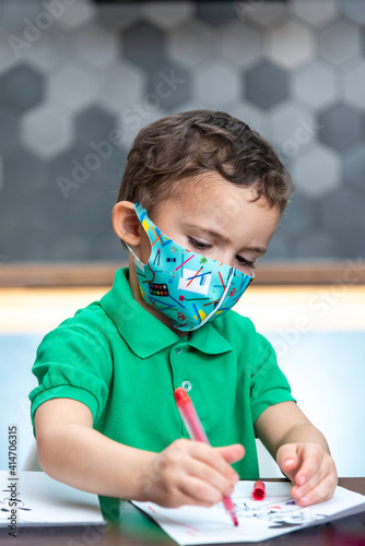 Boy in a mask is drawing