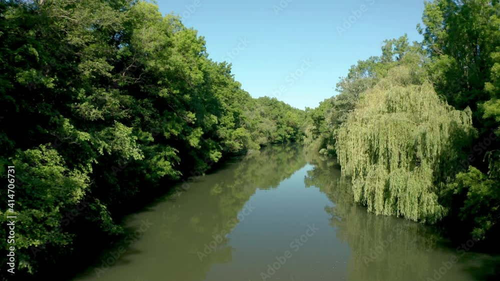 Drone flight along a river surrounded by dense green forest, Kamchia River, Bulgaria. Drone flight along a river surrounded by dense green forest, Kamchia River, Bulgaria.