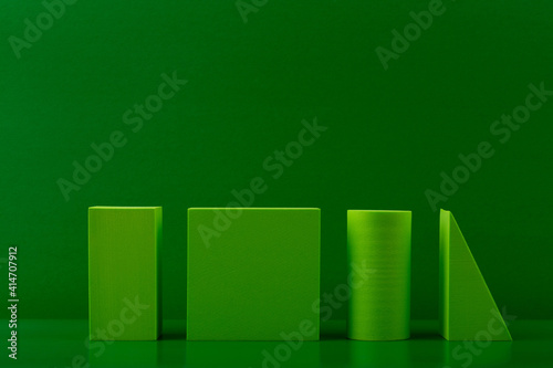 Green monochromatic background with geometric figures against green background with copy space