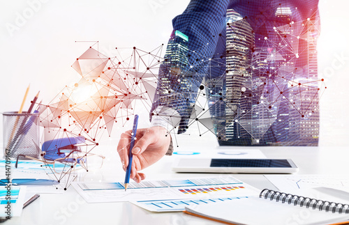Businesswoman standing near office desk with pen