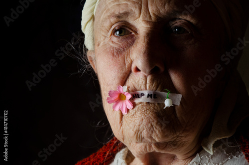 The mouth is sealed with tape. An old grandmother with a sealed mouth. Restriction of freedom and rights. Freedom of thought and speech. Silence. The prohibition to speak. help me
