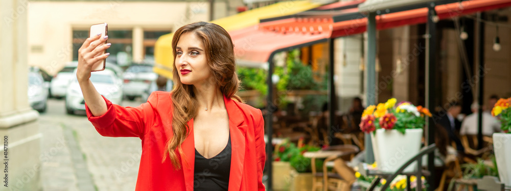 Fototapeta premium Beautiful young caucasian tourist woman takes a selfie in a European city