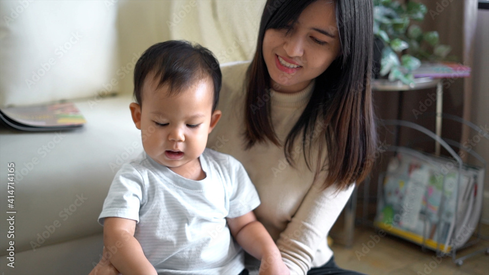 Young mother and little boy child reading book sitting on floor near sofa. Young mother and little boy child reading book sitting on floor near sofa.