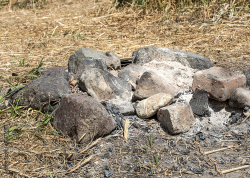 Fototapeta Naklejka Na Ścianę i Meble -  Gray and brown big stones and wood for a bonfire are in a fireplace in the forest